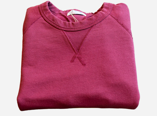 Folded maroon sweatshirt on a green cutting mat with yellow grid lines