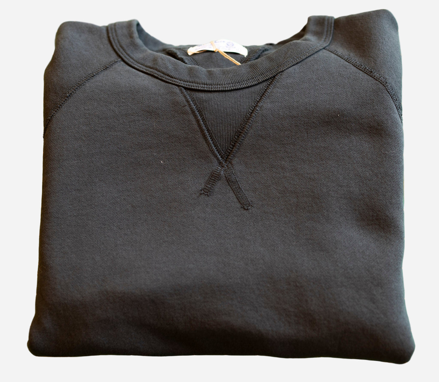 Folded black hoodie on a green cutting mat with grid lines