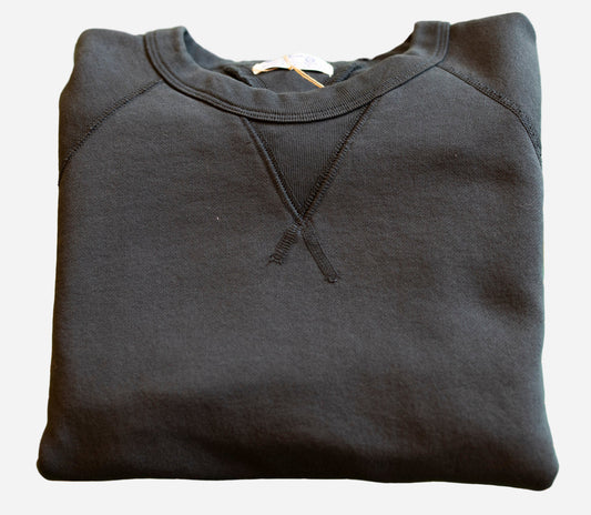 Folded black hoodie on a green cutting mat with grid lines